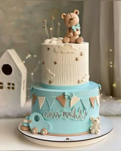 a blue and white cake with a teddy bear on top