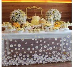 a table topped with cakes and cupcakes covered in flowers