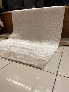 a white sheet sitting on top of a tiled floor