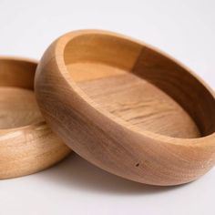 two wooden bowls sitting next to each other