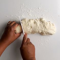 a person is rolling dough on a white surface