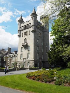 a large castle like building sitting on top of a lush green field