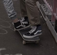 a person riding a skateboard down a street with their feet on the edge of it