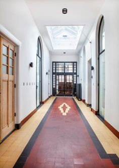 an empty hallway with two doors and windows