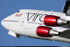 the tail end of an airplane that is painted red and white with black writing on it