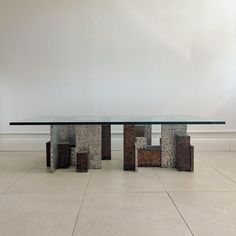 a glass table sitting on top of a tile floor next to a wall with white walls