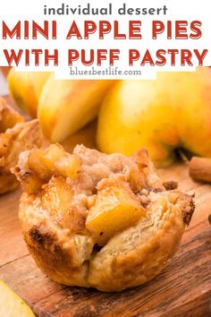 mini apple pies with puff pastry on a wooden cutting board next to sliced apples