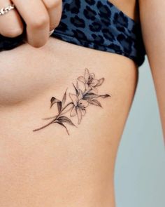 a woman's stomach with a flower tattoo on her side, and the bottom part of her belly