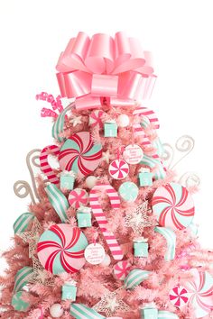 a pink christmas tree decorated with candy canes, candies and lollipops