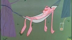 a pink cat laying in a hammock on the ground