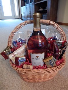 a bottle of wine in a wicker basket filled with chocolates and candies