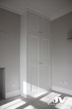 an empty room with white walls and cupboards