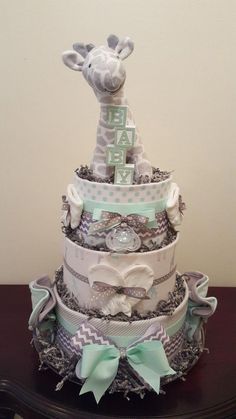 a giraffe themed diaper cake on top of a table with ribbon around it