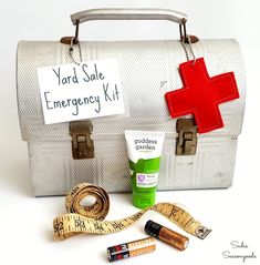 an emergency kit is sitting on top of a white suitcase with a red cross sign attached to it