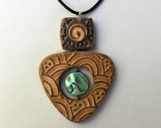 a wooden pendant with a mother's day shell in the shape of a heart