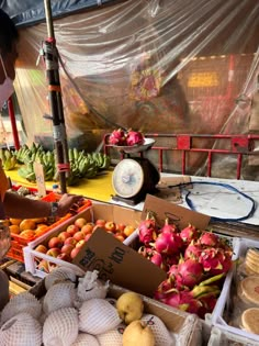 a woman standing in front of a fruit stand