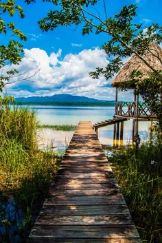 a wooden walkway leading to a hut on the water