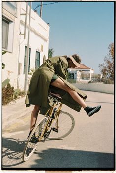 a man riding on the back of a bike down a street