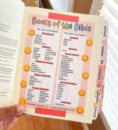 a person holding up a book with the words books of the bible on it