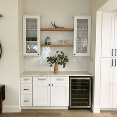 a kitchen with white cabinets and a wine cooler