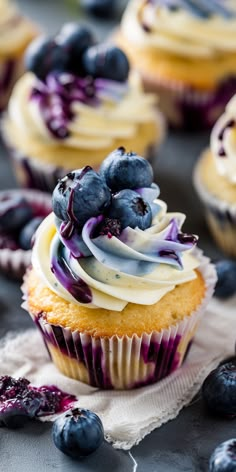 blueberry cupcakes with white frosting and fresh blueberries on the side