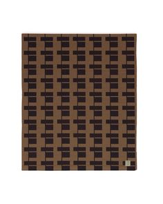 a brown and black area rug with squares on it's side, in front of a white background