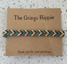 a brown and blue bracelet sitting on top of a card