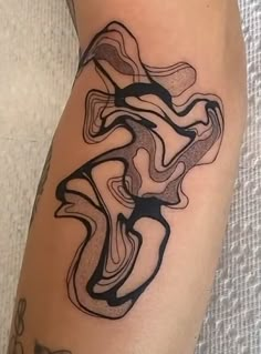 a woman's leg with an abstract tattoo design on the side of her thigh