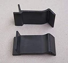 two pieces of black plastic sitting on top of a white floor