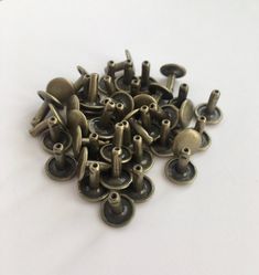 a pile of metal buttons sitting on top of a white table