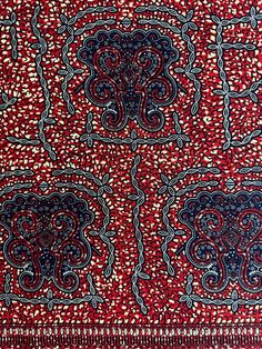 a red and blue paisley pattern on fabric