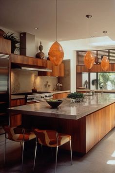 a large kitchen with an island in the middle and lots of cabinets on both sides