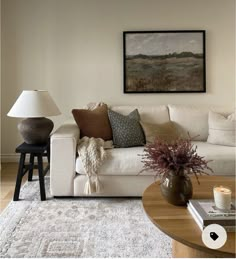 a living room filled with furniture and a painting on the wall above it's coffee table