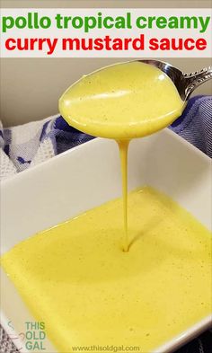 a spoon pouring yellow sauce into a white bowl