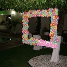 a decorated photo frame sitting on top of a lush green field next to a pool