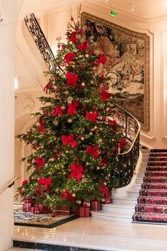 a decorated christmas tree sitting on top of a set of stairs