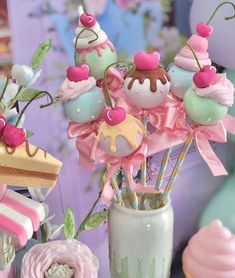 a vase filled with cake and cupcakes on top of a table