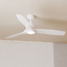 a white ceiling fan mounted to the ceiling in a room with no one around it