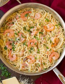 a pan filled with pasta and shrimp on top of a table