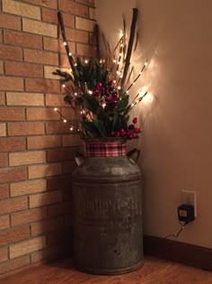 a large metal container with christmas lights in it on the floor next to a brick wall