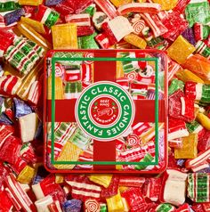 a box filled with assorted candy on top of a pile of other candies