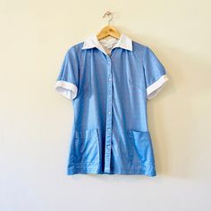 "Vintage 1960s 60s short sleeve tunic top. Blue with red paisley pattern. White collar and sleeves. Buttons up and down the front and has two pockets at the bottom. Buttons on the sleeve as well. The tags are pretty much faded out but I can read that it is made from 100% polyester. Also has the ILGWU women's union tag. Has one small snag as shown, otherwise Excellent vintage condition. Fits like a modern medium. Armpit to Armpit: 19\" Length: 26\" O ABOUT SHOPPE: Mint Moon Shoppe is collection of unique vintage home items and clothing. I bring you magical items so that you can add a \"touch of the old\" into your home, wardrobe and spiritual practice. Follow along on Instagram @MintMoonShoppe I am so glad that you are here...blessed be!" Fitted Collared Top For Summer, Fitted Collar Cotton Blouse, Fitted Cotton Collar Blouse, Fitted Shirt With Pockets For Spring, Short Sleeve Tops With Placket For Daywear, Fitted Retro Summer Blouse, Summer Retro Fitted Blouse, Fitted Summer Blouse With Buttons, Fitted Summer Blouse With Button Closure