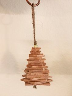 a wooden christmas tree ornament hanging from a rope