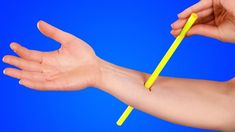 a hand holding a yellow toothbrush with it's arm extended to the side