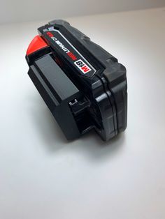 a black and red tool box sitting on top of a table