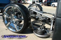 a wheel chair sitting on the side of a road next to a blue truck and other cars