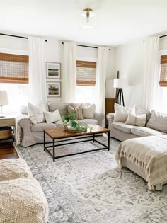 a living room filled with white furniture and lots of pillows on top of it's couches