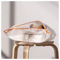 a white bag sitting on top of a wooden stool