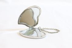 a small mirror with a chain attached to it