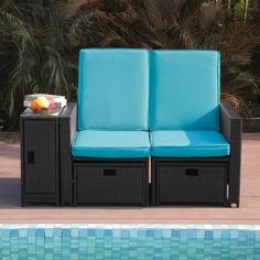 two blue chairs next to a pool with an orange fruit on the table in front of it